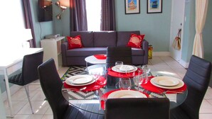 A dining area with a glass table set for four, surrounded by black chairs. - Beautiful Studio on Collins Ave by the Beach with Private Parking (Miami Beach)