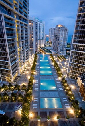 A high-rise hotel with multiple swimming pools, arranged in a central axis, surrounded by tall buildings. - Beautiful apartment in the heart of downtown, 44th Floor (Miami)
