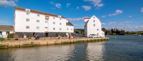 A waterfront building with multiple floors and a dock extending into the water.