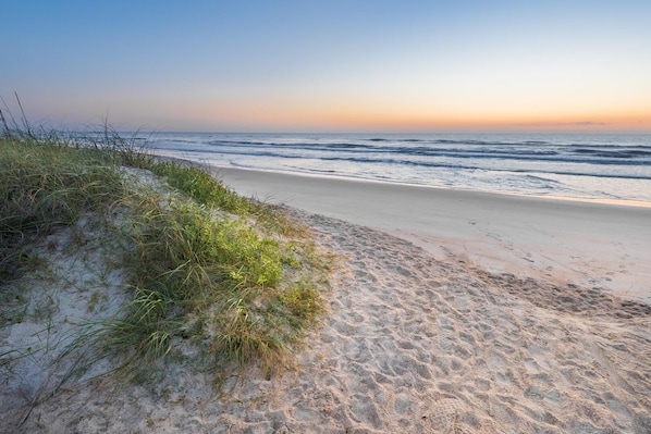 Enjoy a serene beach experience with gentle waves and vast ocean views.