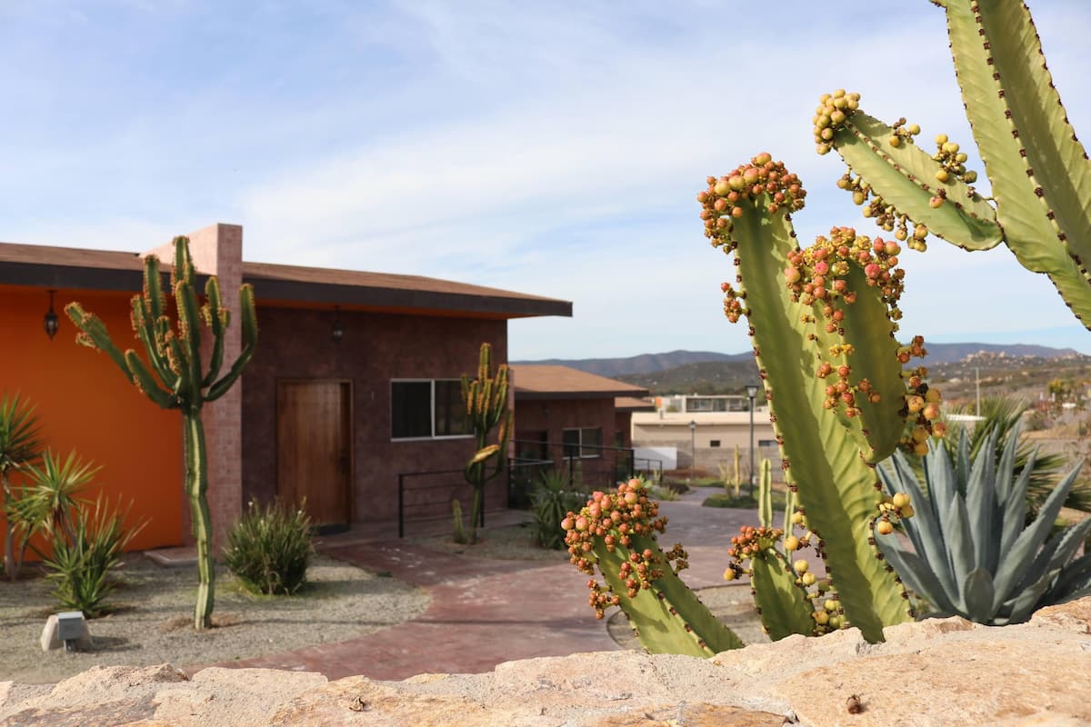 A desert landscape with a building featuring a brick facade and a flat roof.