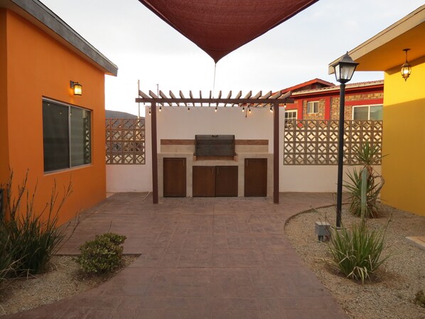 A patio area with a pergola, outdoor seating, and a barbecue grill. - Casitas del Valle (Valle de Guadalupe)