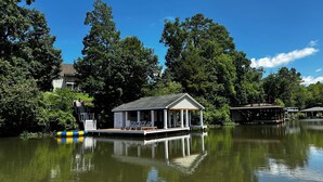 A floating house with a covered deck and a small pool.