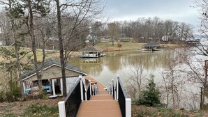A wooden bridge leading to a dock with a small building nearby.