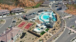 An aerial view of a resort with a swimming pool, tennis courts, and a landscaped area with lounge chairs. - Waterpark Retreat w/ Lazy River, Pickleball Courts (Washington)