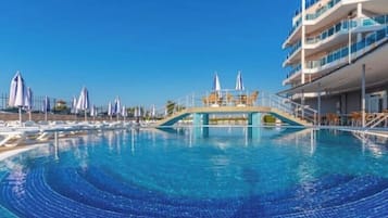 Relax by the pool surrounded by lounge chairs and umbrellas.