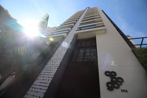 Een modern gebouw met een opvallende ingang, een reeks ramen en een bijzondere geperforeerde gevel.