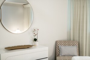 A bedroom with a bed, a bedside table, a mirror, and a window with curtains. - Sun View On Seaview - Airlie Beach (Airlie Beach)