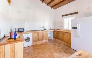 Enjoy cooking in this well-equipped kitchen with appliances, including a washing machine, microwave, and refrigerator.