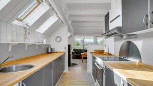A modern kitchen with wooden countertops, stainless steel appliances, and a skylight. - 3 bedroom lovely home in Slagelse (Slagelse)