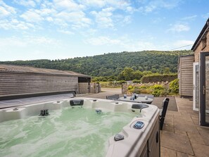 A hot tub with a control panel, a wooden building, and a view of a hilly landscape. - 4 bedroom accommodation in Trevor, near Llangollen (Trevor, near Llangollen)