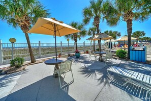 Relax by the ocean with a view, surrounded by palm trees and comfortable seating under shaded umbrellas.