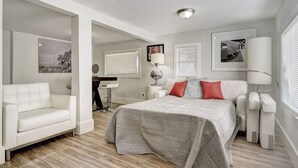 Un dormitorio moderno con una cama grande, un sofá blanco y un escritorio.