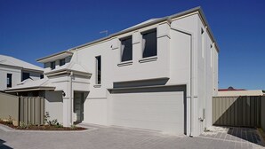 A modern two-story house with a garage, a covered driveway, and a small garden area. - Brand New Home on Perth Doorstep (Bayswater)