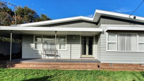 A single-story house with a covered porch, a front door, and a small front yard. - Cosy Mid-Century home, Central, Off Street Parking and Fur Baby Friendly (Newington)
