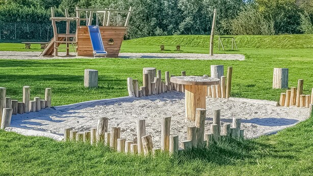 Un parque infantil con tobogán y estructuras para escalar.