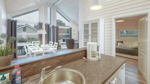 Una cocina moderna con un amplio ventanal, una zona de comedor y un rincón de estar acogedor.