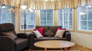 Una sala de estar acogedora con un sofá, un sillón y una mesa redonda de centro.