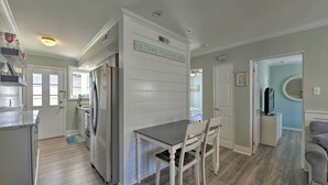 A kitchen with a dining table and chairs, a refrigerator, and a door with a sign. - Beach Block Wildwood Condo - Proximity to Dining! (Wildwood)