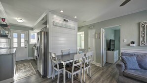 A modern kitchen with a dining table and chairs, a refrigerator, and a gray couch in a living area. - Beach Block Wildwood Condo - Proximity to Dining! (Wildwood)