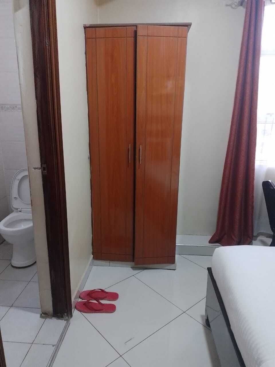A bedroom with a bed, a wardrobe, and a toilet.