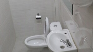 Un baño con inodoro, lavamanos y ducha.