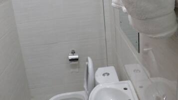 Un baño con inodoro, lavamanos y ducha.