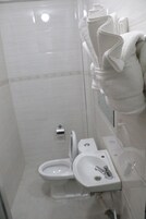 Un baño con inodoro, lavamanos y ducha.