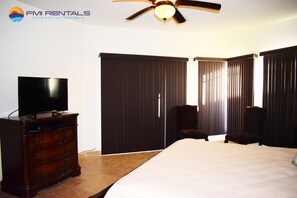 Relax in a spacious room with a large bed, a dresser, and a flat-screen TV.