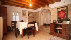 Un comedor con una mesa y sillas de madera, un armario y un cuadro en la pared.