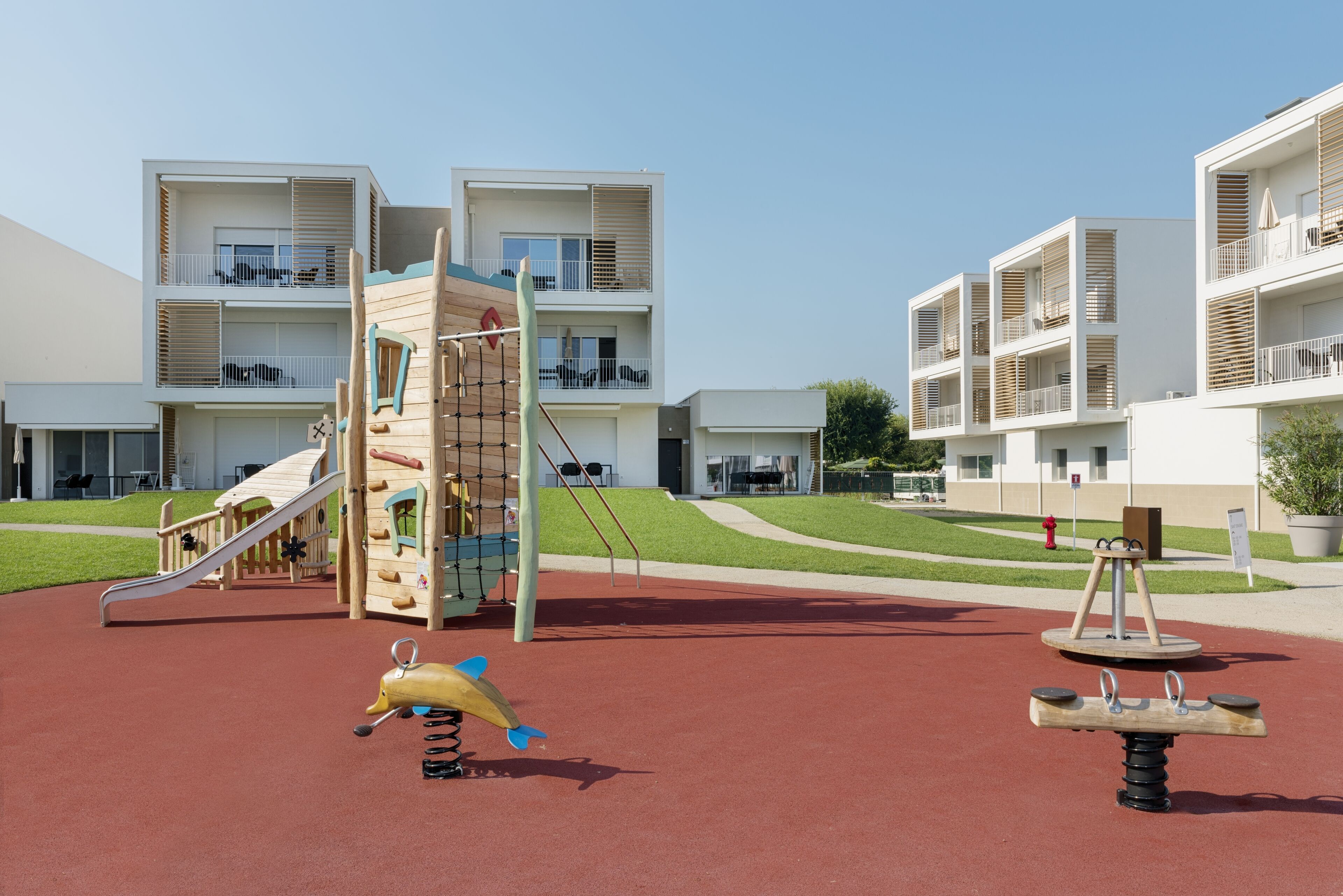 A playground with a slide, climbing structure, and swings.