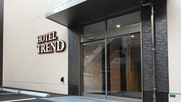 Ein Hotel Eingang mit modernem Design, mit einem gut sichtbaren Schild mit der Aufschrift 'HOTEL TREND'.