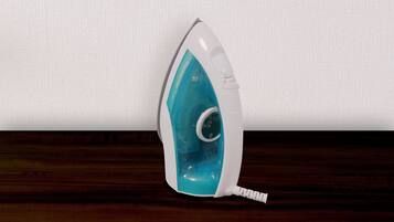 A white and teal iron on a wooden surface.