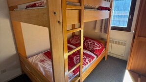 A bunk bed room with a window and a radiator.