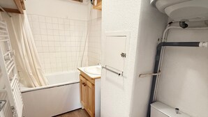 A compact bathroom with a bathtub, toilet, and sink.