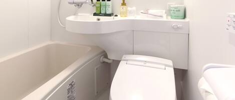 A bathroom with a bathtub, toilet, and sink.