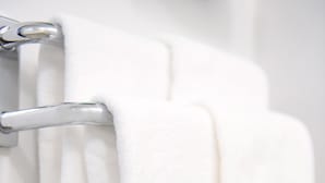 A white towel hanging on a metallic towel rack. - Hotel Trend Omiya (Saitama)