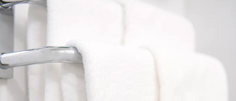 A white towel hanging on a metallic towel rack.