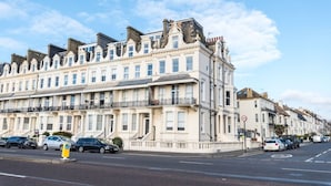 A row of classic, multi-story buildings with uniform architectural style, featuring balconies and a street in front. - Immaculate 1-bed Apartment on Hove Seafront (Hove)