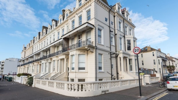 A historic building with a white facade, multiple balconies, and a 20 mph speed limit sign. - Immaculate 1-bed Apartment on Hove Seafront (Hove)