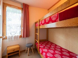 A bunk bed room with a wooden headboard, a small stool, and a window with lace curtains. - 3-room apt, 4 ppl, balcony, Hameau du Mottet (Valmorel)