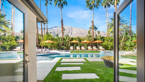 A pool area with palm trees, umbrellas, and lounge chairs. - Mountain Views, Pool and Near Downtown (Palm Springs)