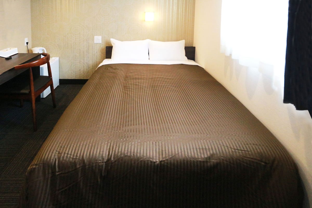 Ein Hotelzimmer mit einem Bett, einem Schreibtisch und einem Stuhl.
