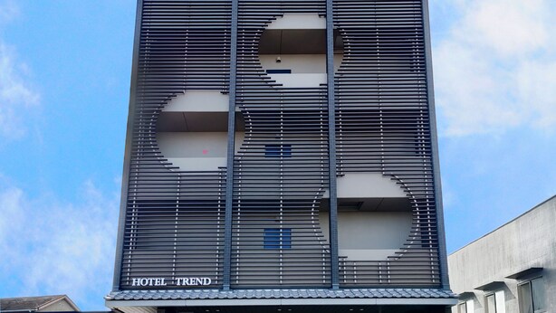 Ein modernes Hotelgebäude mit einer markanten Fassade, die sich durch horizontale Lamellen und ein kreisförmiges Design auszeichnet.