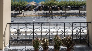 A balcony with a view of the sea, potted plants, and a metal railing. - Aigli Seafront Loft-Bespoke Design Gem (Kalamata)
