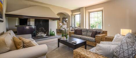 A living room with a fireplace, sofas, and a coffee table.