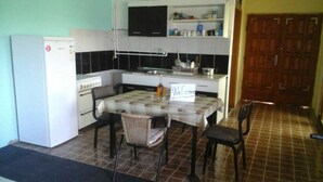 Cocina compacta con refrigerador, estufa y una mesa con un cartel que dice 'Welcome'.