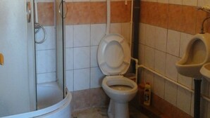 Un baño con inodoro, cabina de ducha y lavamanos.