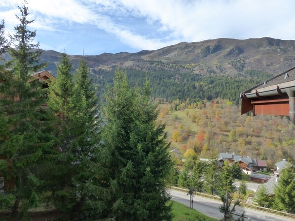 A mountainous landscape with a road leading to a cluster of houses.