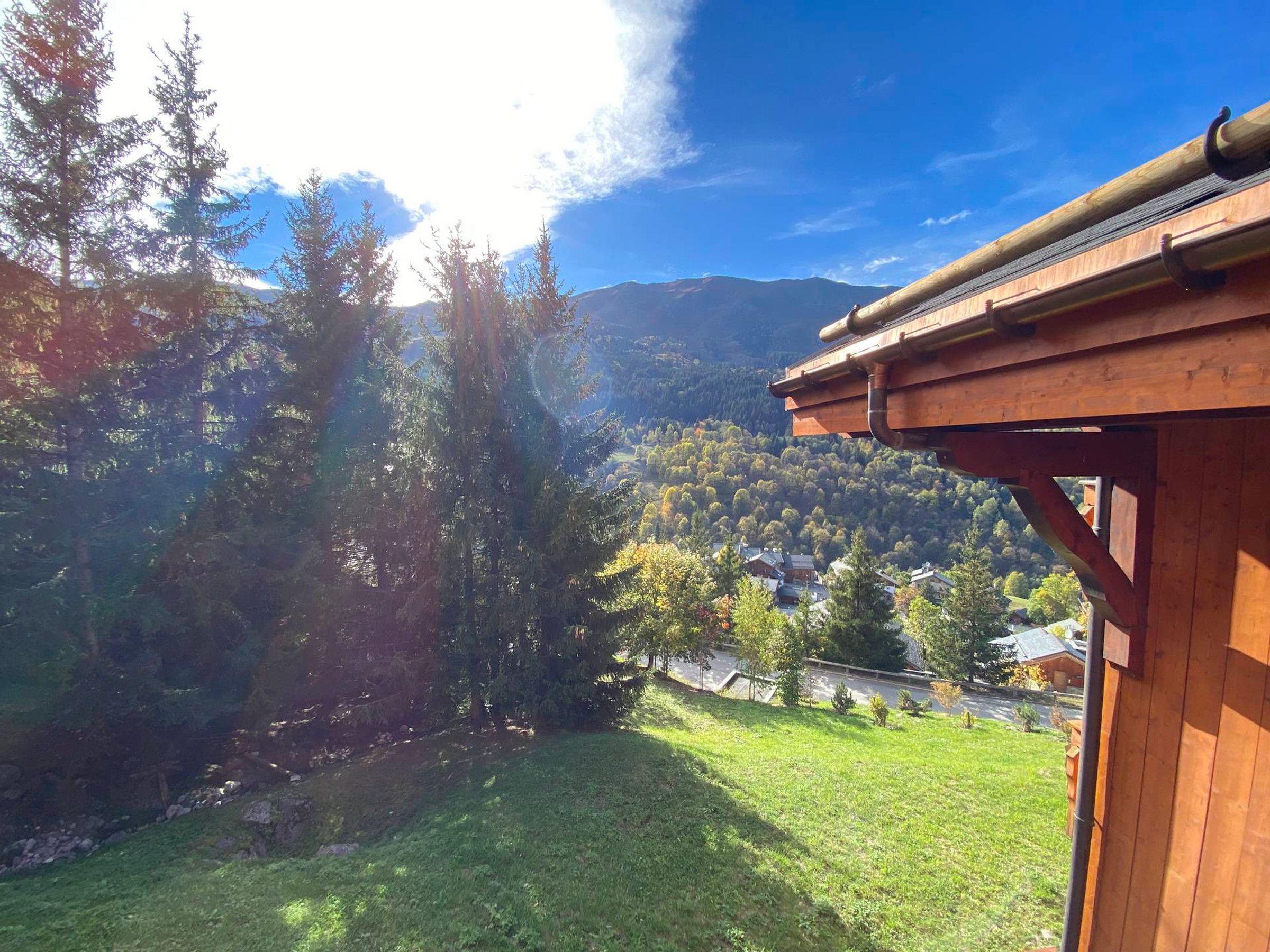 A wooden cabin with a view of a forest and mountains.